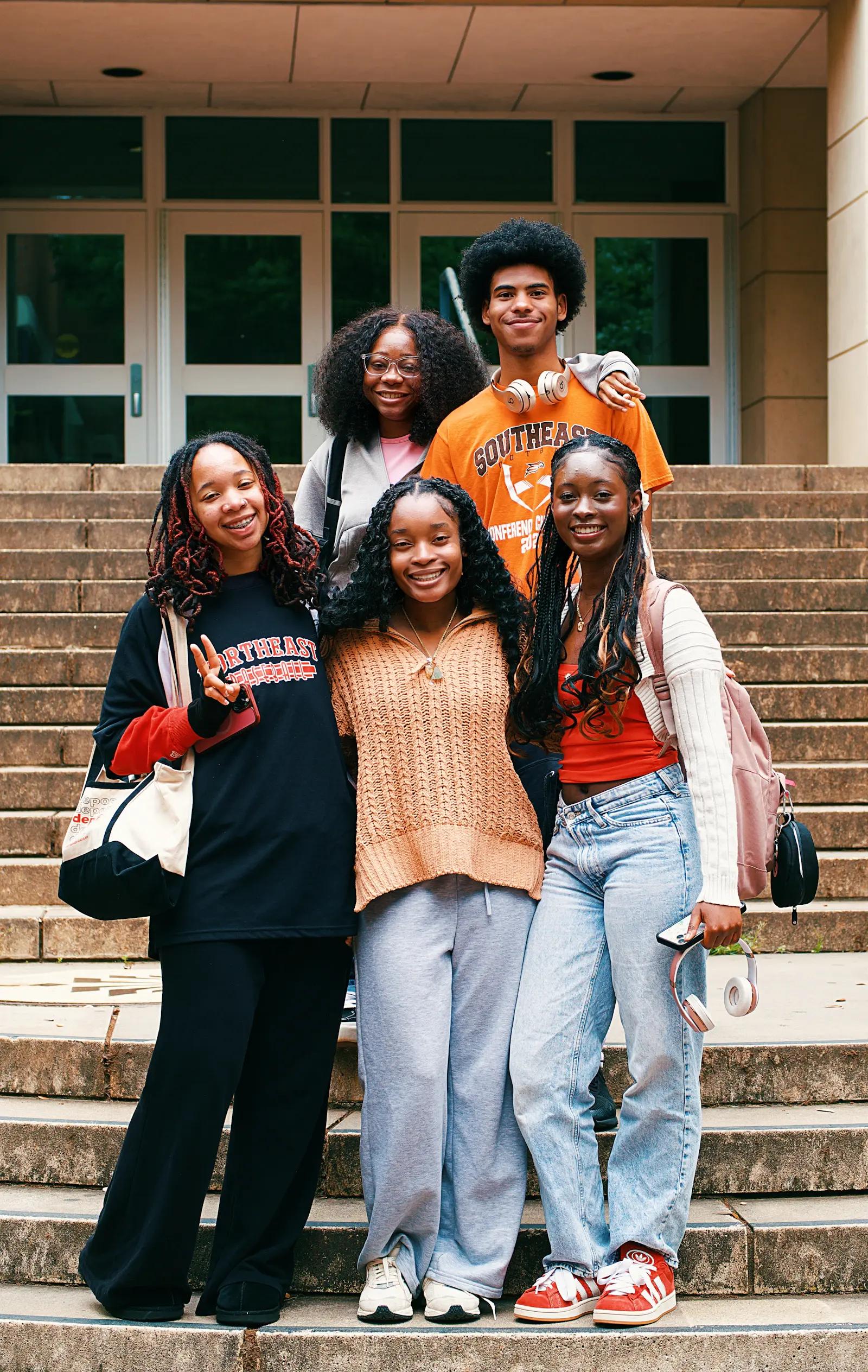 A group of friends smiling together on outdoor steps